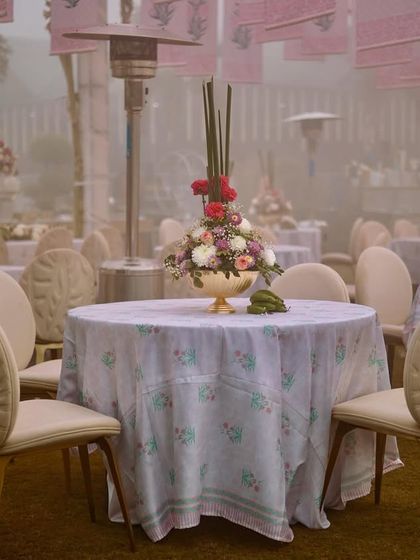 An atmospheric shot of the guest seating on a foggy morning, with elegant tables set with printed linens and floral centerpieces.