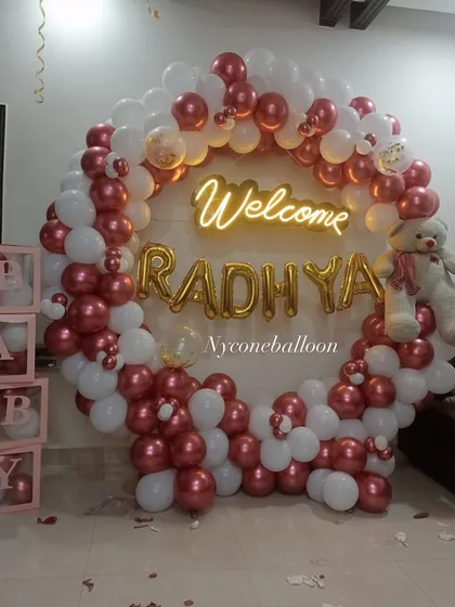 Bringing your baby home is a moment to cherish. I can prepare a beautiful 'Welcome Home' decoration at your place, like this personalized ring backdrop for 'Welcome RADHYA' with a cute teddy bear.