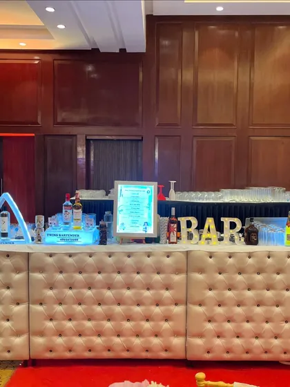 The full 16-foot white tufted bar, ready for a large corporate party. We can scale our setups to accommodate any number of guests.