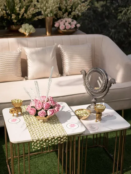 Elegant table decor for a wedding, featuring small floral arrangements, custom coasters, and a vintage-style mirror.