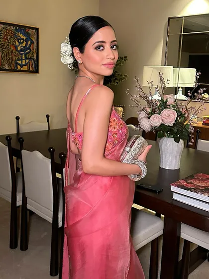 A side profile of Sunaina Khera's look, highlighting the elegant hairstyle and the radiant makeup.