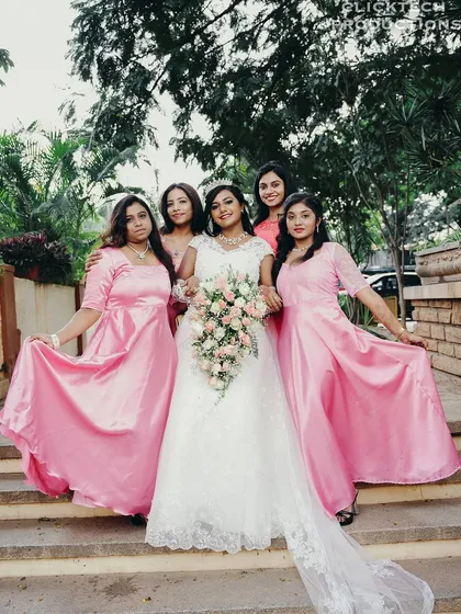 A classic group portrait of the bride and her bridesmaids, showcasing their coordinated outfits and happy smiles.