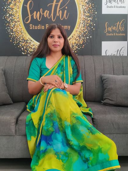 Posing for a photo at my studio. This vibrant saree reflects my personality.