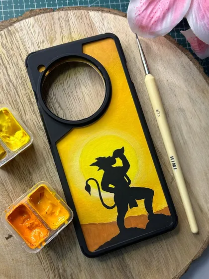 A minimalist yet powerful design of Hanuman carrying the Dronagiri mountain, painted as a silhouette against a vibrant sunset. This custom phone cover uses a warm color palette of yellows and oranges to create a striking visual.
