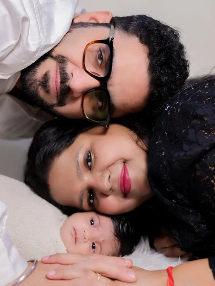 A similar overhead family portrait, this time with the family's heads close together. This composition creates a feeling of closeness and unity, perfectly framing the newborn's sweet face.