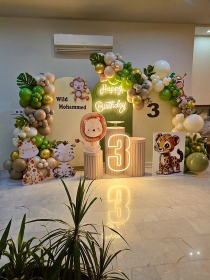This 'Wild Mohammed' jungle theme uses earthy tones of green and beige balloons, paired with cute animal characters and a neon number '3' for a stylish celebration.