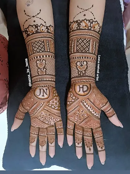 A beautiful example of incorporating the couple's initials into the bridal design. The letters 'J' and 'N' are elegantly placed within the intricate patterns on each palm.