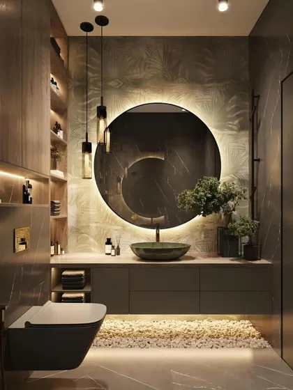 We designed this luxurious bathroom with a moody, dramatic feel. The custom vanity includes under-lit drawers and open shelving, complemented by a large, circular backlit mirror that creates a stunning focal point.