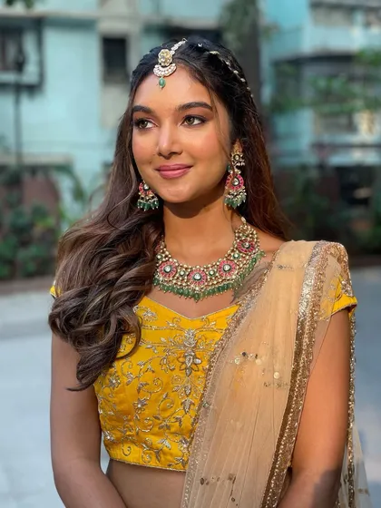 The client looking like a ray of sunshine in her yellow outfit. The hairstyle is fun, youthful, and perfectly suited for the event.