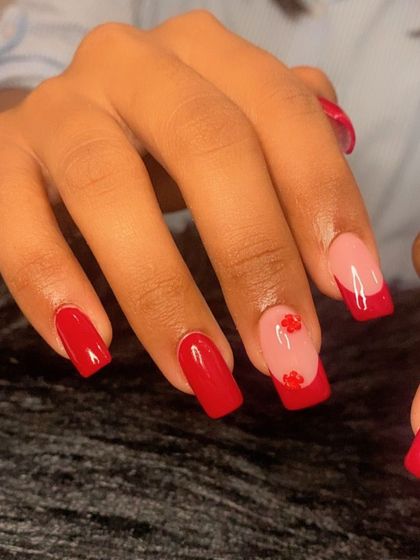 Another angle of the red manicure with floral embellishments.