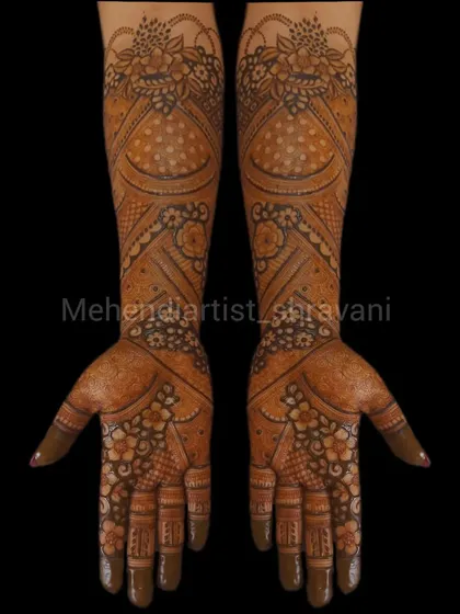A classic and symmetrical design suitable for a bridesmaid or guest. It features floral and paisley patterns that cover the hands and extend partially up the arm.