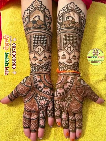 A classic bridal design featuring peacocks, elephants, and hanging jhumkis. The personalized initial 'M' adds a modern touch to the traditional motifs.