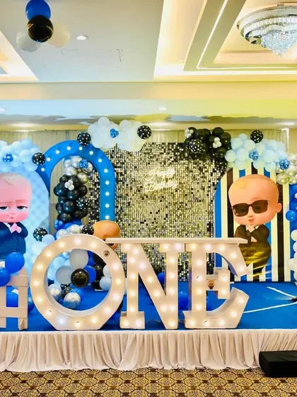 We bring your child's favorite characters to life with our fun themed parties. This Boss Baby first birthday stage includes a silver shimmer wall, character cutouts, themed props, and large "ONE" marquee letters for a memorable celebration.