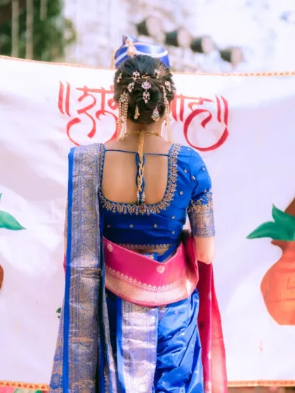 The back of the bridal look is just as important as the front. Here, you can see the beautifully adorned bridal bun and the perfect drape of the Paithani saree, creating a stunning silhouette.