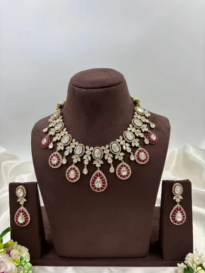 The red meenakari drop polki necklace on a mannequin.