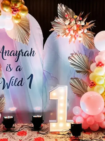 A boho-chic 'Wild 1' birthday theme for Anayrah. We used pastel balloons, dried palm leaves, and a light-up number '1' to create a stylish and modern take on the classic first birthday theme.