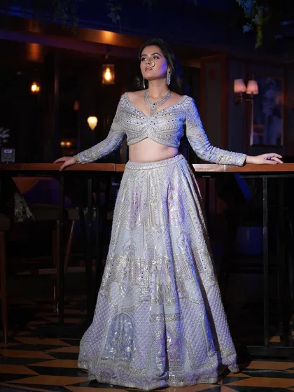 A full-length shot showcasing the entire ensemble. The makeup is glamorous enough to match the heavily embellished outfit.