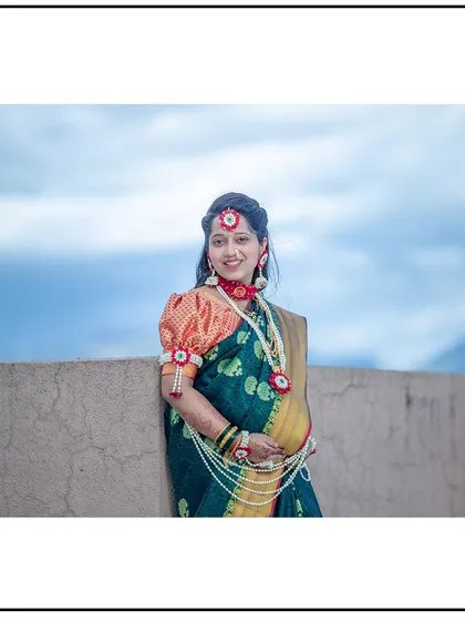 A beautiful portrait of a mom-to-be in a traditional green saree and floral jewelry, ready for her baby shower ceremony.