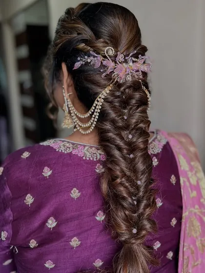 I believe a bride's hairstyle should be a work of art. This intricate fishtail braid, woven with delicate pearl chains and crowned with a floral accessory, is a perfect example of the romantic and detailed hair artistry I provide.