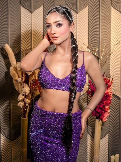 A full view of the 'Mermaid' look, complete with a long, braided ponytail and a sparkling purple two-piece outfit.