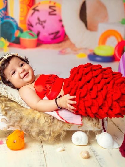 A happy little mermaid enjoying her beach day. The bright colors and fun props make this a lively and cheerful photoshoot.