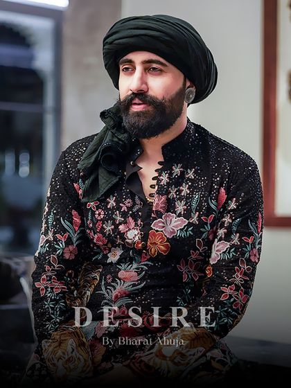 A portrait of modern regality. The dense floral embroidery on this black kurta provides a rich texture and a narrative of opulence. This is how I redefine traditional Indian menswear for today's powerful man.
