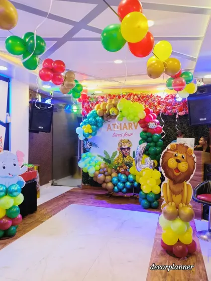 This shot captures the full party atmosphere, with balloon bunches on the ceiling and animal-themed columns at the entrance, all leading to the main stage. It shows how I can decorate an entire venue to fit your theme.