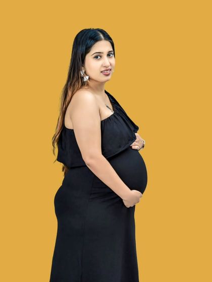 Confidence and a baby bump. This portrait pairs a simple black dress with a bold yellow background, creating a modern and striking image that celebrates the mother's vibrant energy.