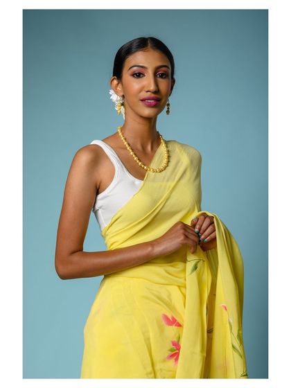 A close-up portrait that showcases the model's pleasant expression and the cheerful color of the yellow saree.