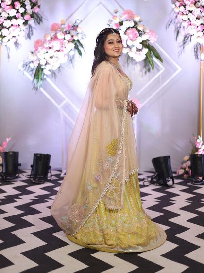 The full view of this pastel yellow lehenga shows its graceful A-line silhouette and the sheer, embroidered dupatta. It’s a versatile piece that allows you to look festive while feeling comfortable.