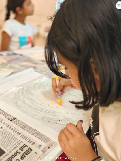 A student carefully works on a wreath design, combining lettering with illustrative elements for a beautiful final piece.