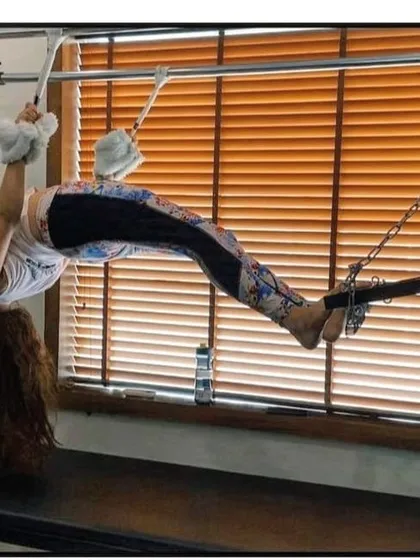 This inverted hanging exercise on the Cadillac helps to lengthen the spine and strengthen the entire posterior chain. It's an advanced move that demonstrates incredible body control.