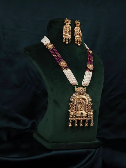 A side-angle view of the traditional necklace set on a bust, highlighting the depth and dimension of the pendant and beadwork.