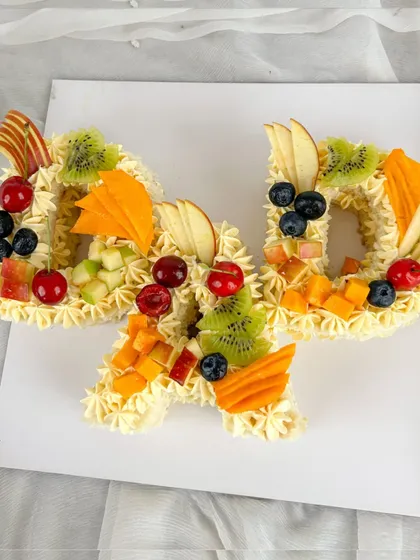 A personalized "DAD" monogram cake, decorated with fresh, colorful fruits. It's a fresh and delicious way to celebrate your hero.