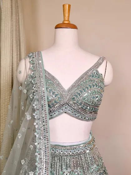 A close-up of the exquisite teal green lehenga blouse. The silver sequin and beadwork are incredibly detailed and perfect for a glam look.