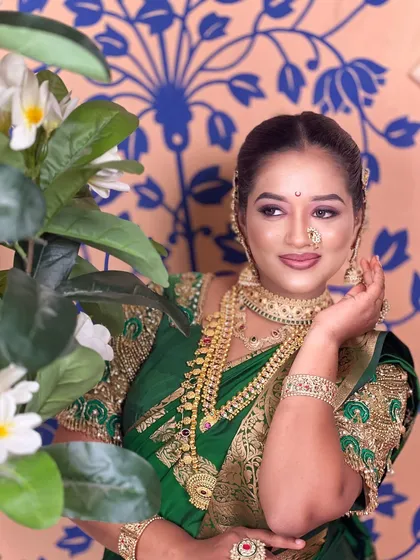 A classic pose showcasing the rich embroidery on the blouse and the heavy gold jewellery.