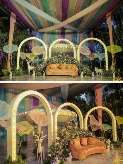 A whimsical, forest-themed stage decoration. The setup features illuminated arches, large mushroom-like props, and statues of deer and rabbits, creating a magical and enchanting fairytale setting.