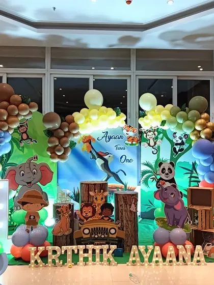 A wide view of a Lion King inspired jungle party, showcasing the full scale with large animal cutouts and extensive balloon work.