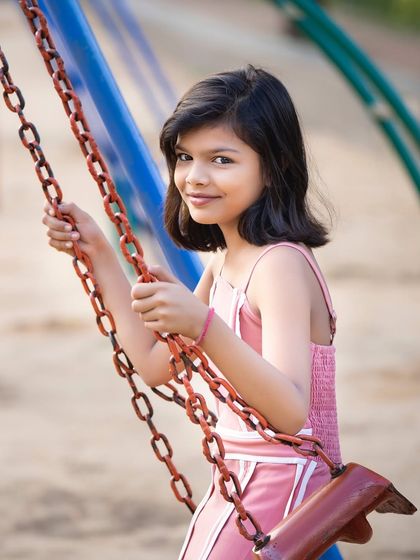 A classic childhood moment on the swings. We capture the simple joys of being a kid during our outdoor portrait sessions, resulting in natural and happy photographs.