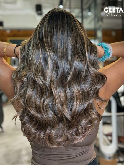 Beautifully blended balayage on long, wavy hair, creating a sun-kissed and natural look.