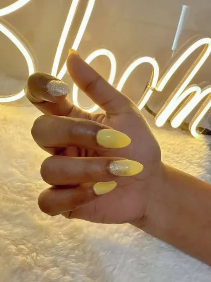 A fun shot of the yellow sunshine nails against our studio's neon sign.