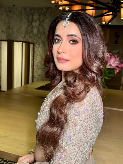 This portrait captures the soft glam of the reception look. The makeup enhances her features beautifully, creating a look that is both modern and timeless.