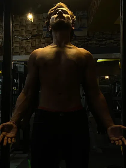 A client showing his lean, muscular physique under dramatic lighting. This is the "monster" that can be unleashed with proper training.
