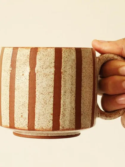 The Coffee Drip cup is designed for a comfortable grip. Its earthy, speckled glaze and clean vertical lines give it a warm, contemporary feel that fits in any kitchen.