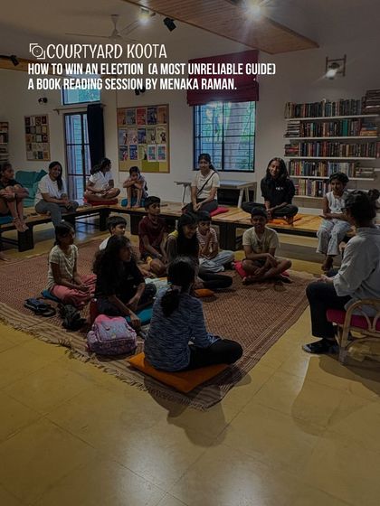 A book reading session for "How to Win an Election (A Most Unreliable Guide)" with author Menaka Raman. The children are seated informally, creating a relaxed and engaging atmosphere for the story.