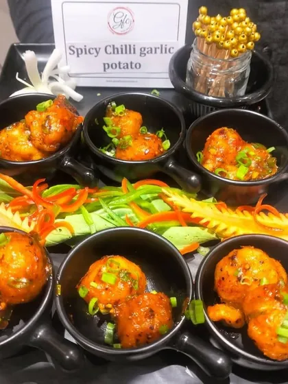 Our spicy chili garlic potatoes are served in individual mini pans, making them a fun and flavorful addition to any appetizer spread.