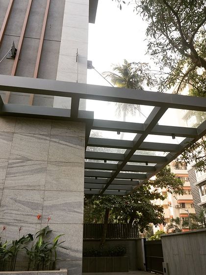 We designed a sleek glass and metal canopy at the building's entrance to protect the car lift doors from the weather while complementing the modern façade design.