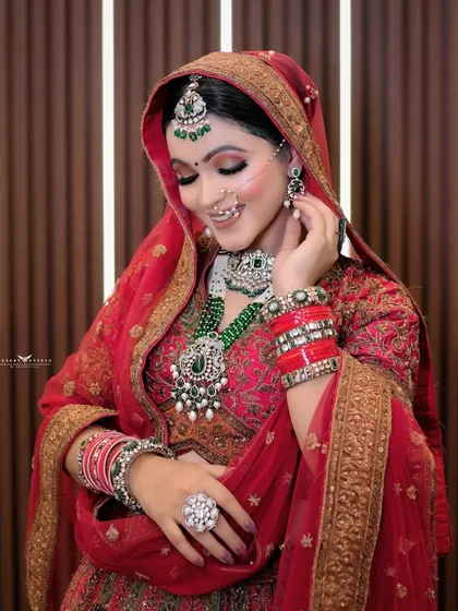 A colorful portrait of the bride adjusting her earring, highlighting the jewelry and her gentle smile.