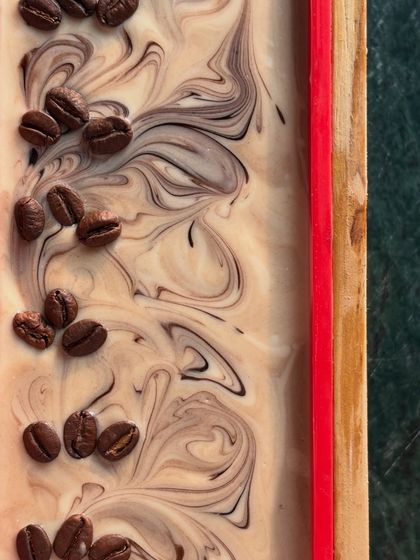 A beautiful swirl top on our coffee soap, decorated with whole coffee beans before it sets. This is one of our favorite parts of the creative process.