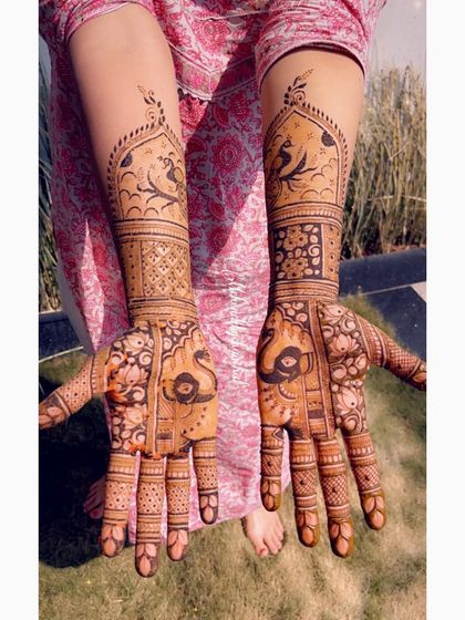 A stunning bridal design with peacock motifs on the palms and jharokha designs on the arms. The mix of bold and fine lines creates a beautiful texture.